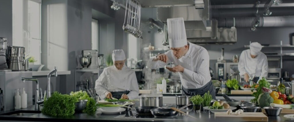 Chefs cuisiniers travaillant dans une grande cuisine équipée d’appareils professionnels au Maroc.