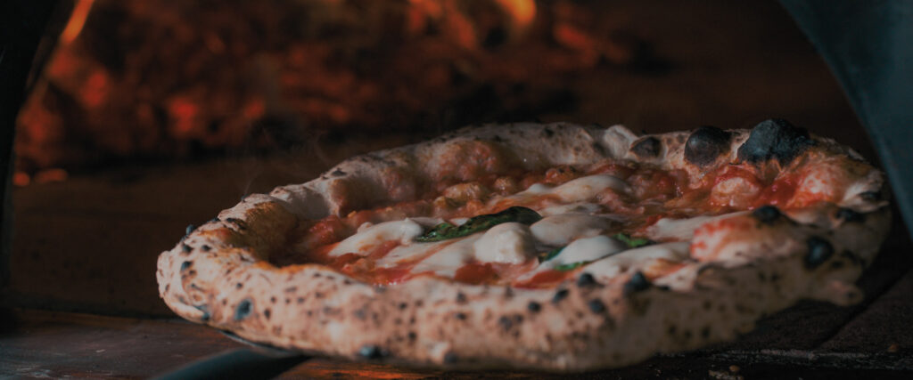 Four à pizza professionnel en fonctionnement dans une pizzeria au Maroc.